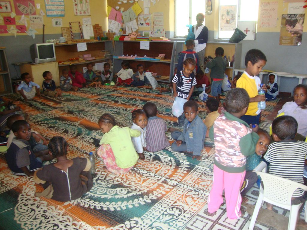 Children and caregivers gathered in a community learning space